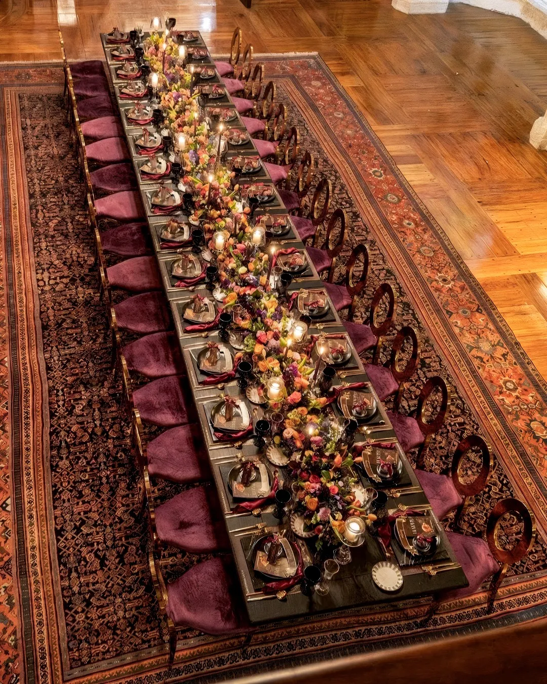 Mesa imperial larga con sillas de terciopelo vino y velas