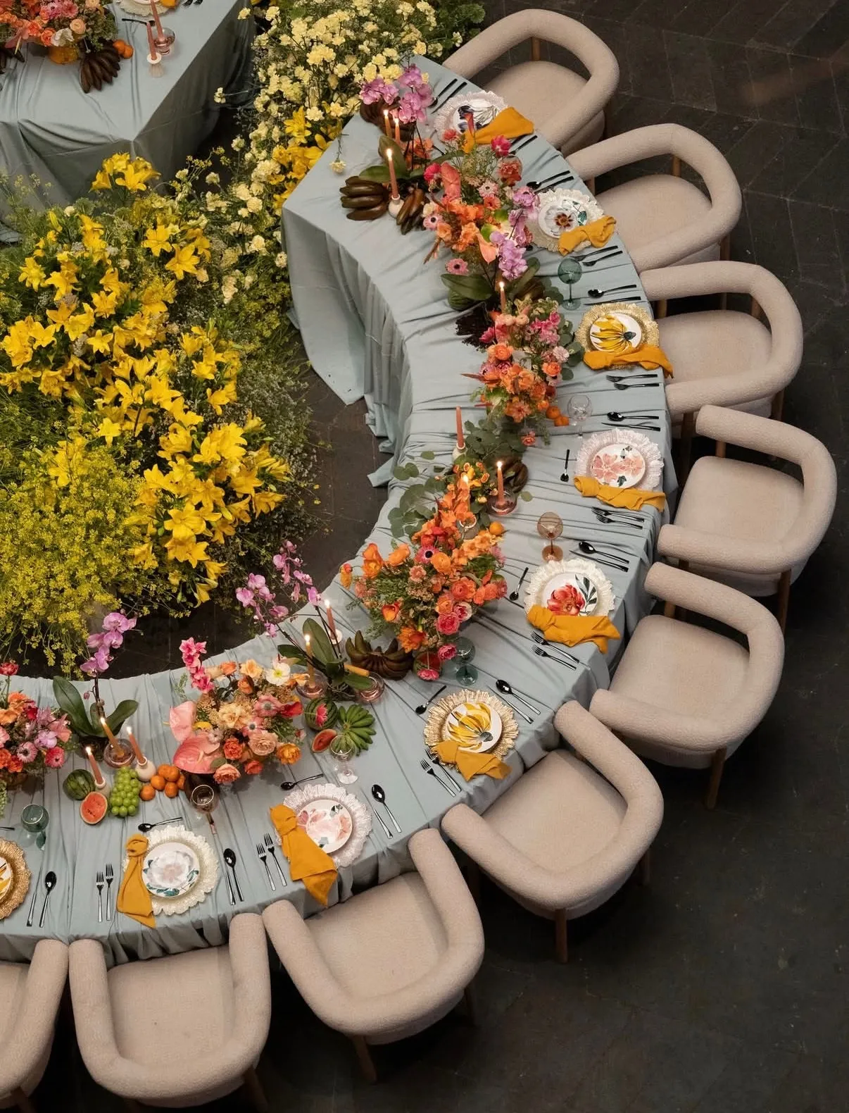 Mesa curva con arreglos florales amarillos y sillería boucle