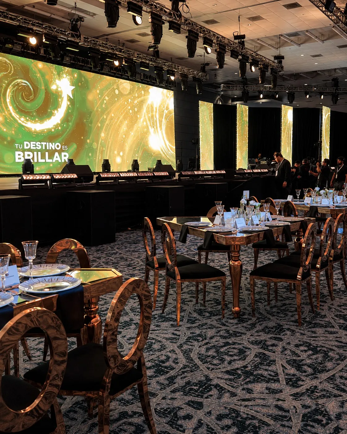 Evento corporativo con escenario, pantalla LED y mesas de banquete